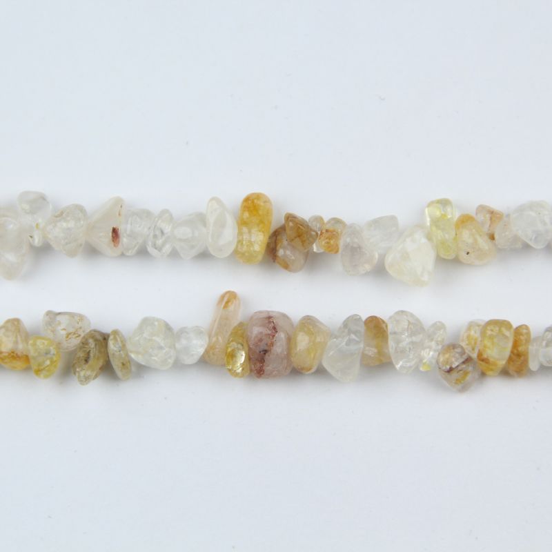 macro closeup of yellow floral inclusion quartz bead showing golden-yellow flake inclusions within transparent quartz