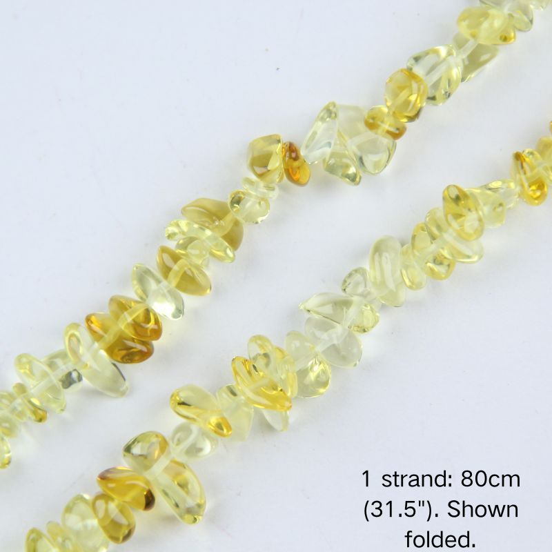 Macro close-up of glossy yellow 5-8mm irregular glass chip beads, showcasing the polished texture, translucency, and center-drilled holes.