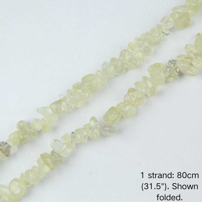 Macro close-up of yellow quartz chip beads, 5-8mm polished irregular chips with natural golden translucency.